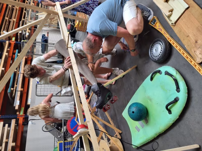 Kinderen en medewerkers bouwen met hout en ballen aan de kettingreactie bij Almetaal